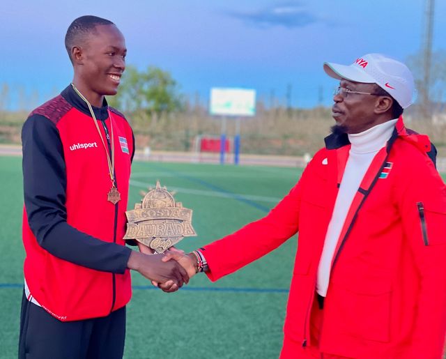 Elisha receiving the Costa Daurada Cup trophy on behalf of the team from CS Ababu Namwamba